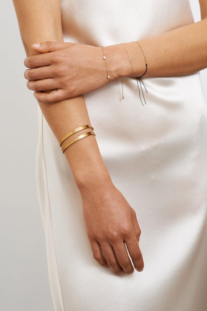 Model torso view with assortment of bracelets including Gemma Diamond Cuff Bracelet bagatiba 