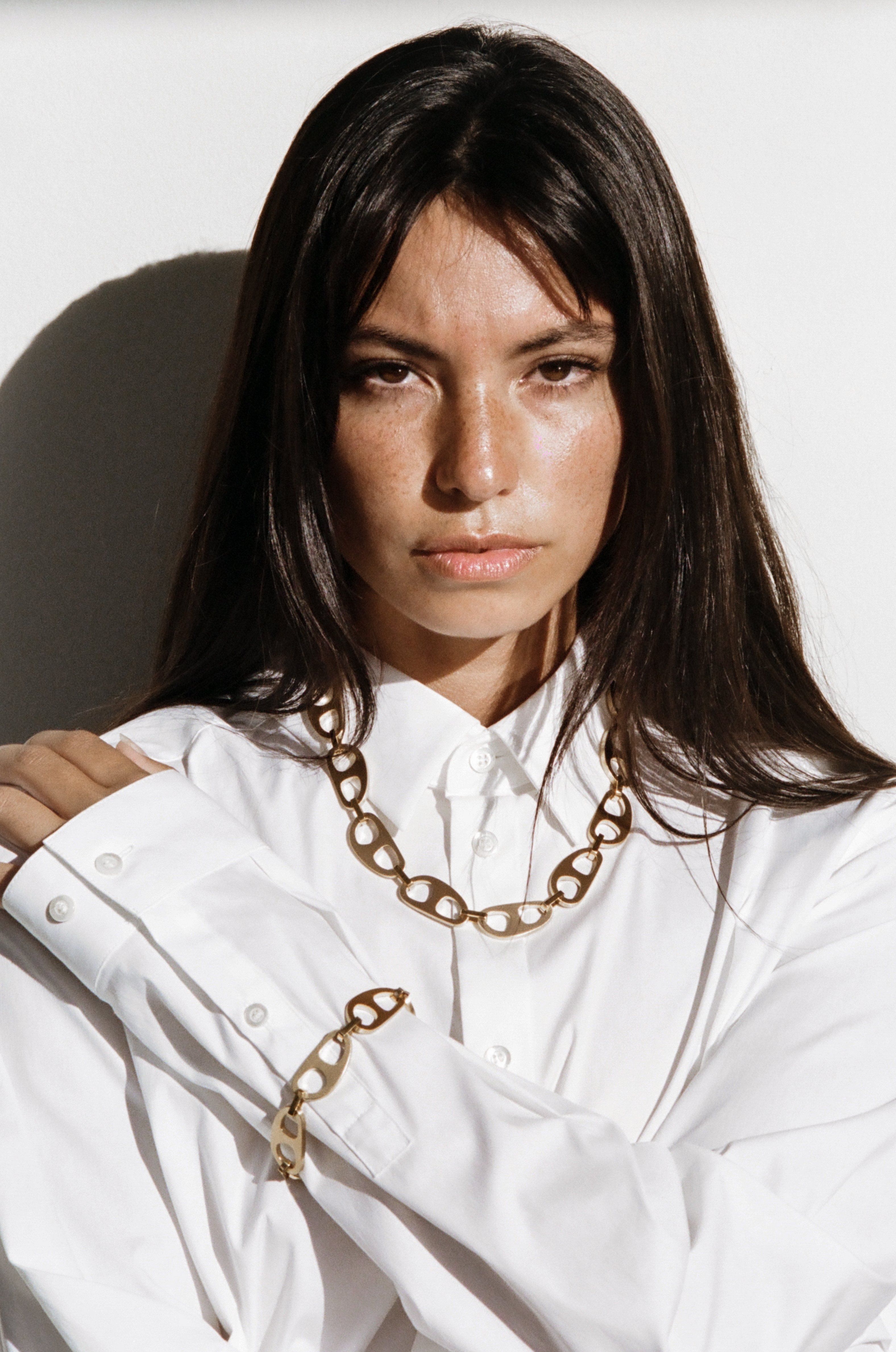 Close view of Model wearing Gold Brushed Tab Necklace in natural light bagatiba 