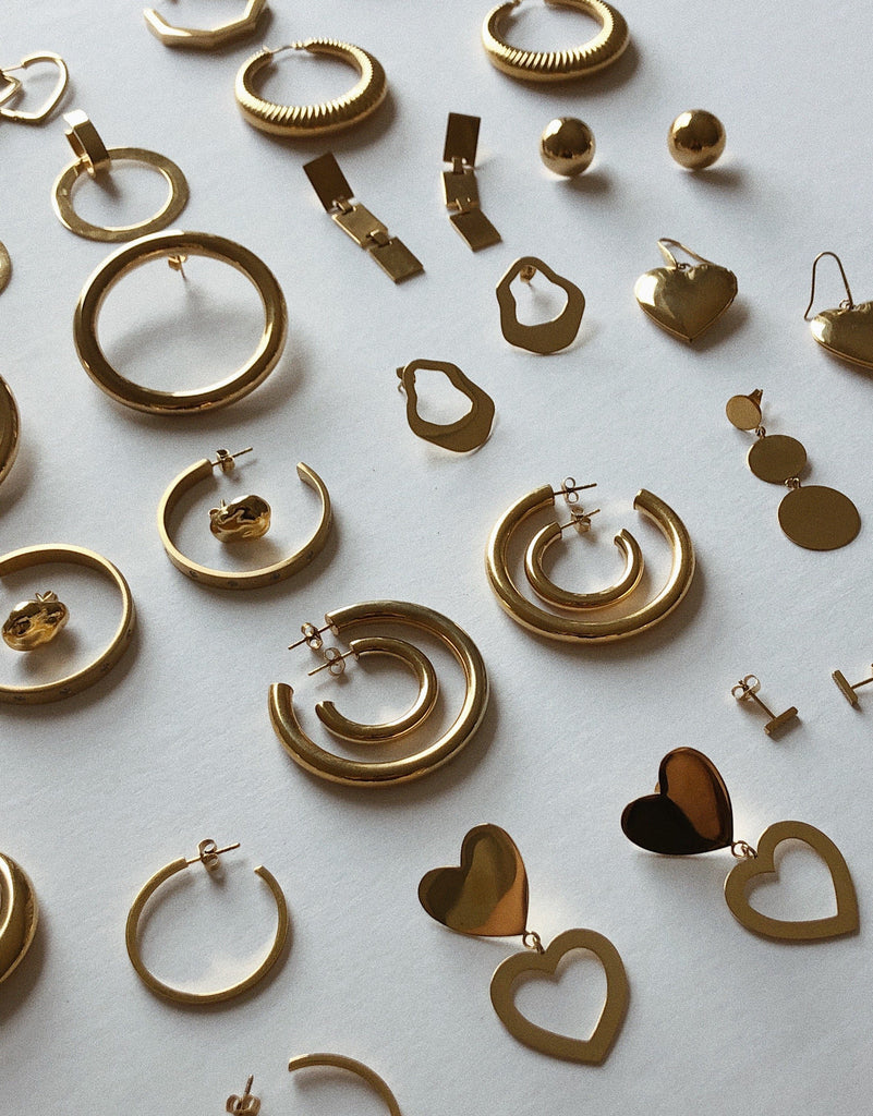 Flat lay detail view of eco earrings including Gold Hollow Hoops Earrings Bagatiba 