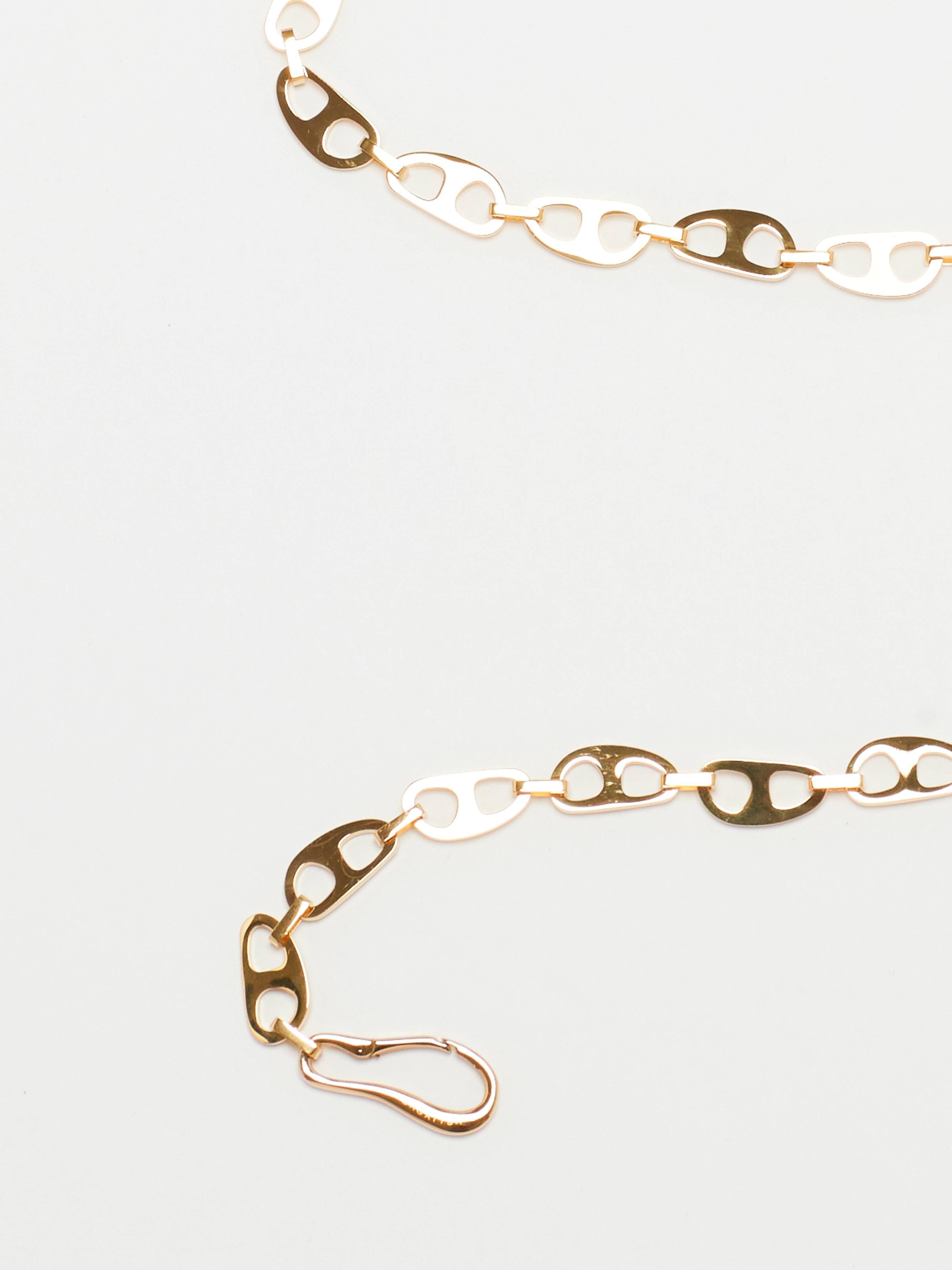 Detail cropped view flat lay of Gold Tab Crossbody Belt Body bagatiba 