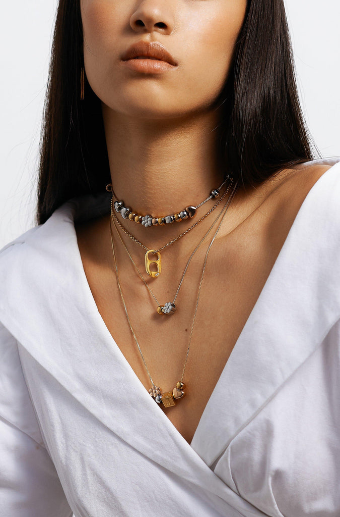 Model wearing 4 necklaces of different lengths layered with Letter Block letters Bagatiba