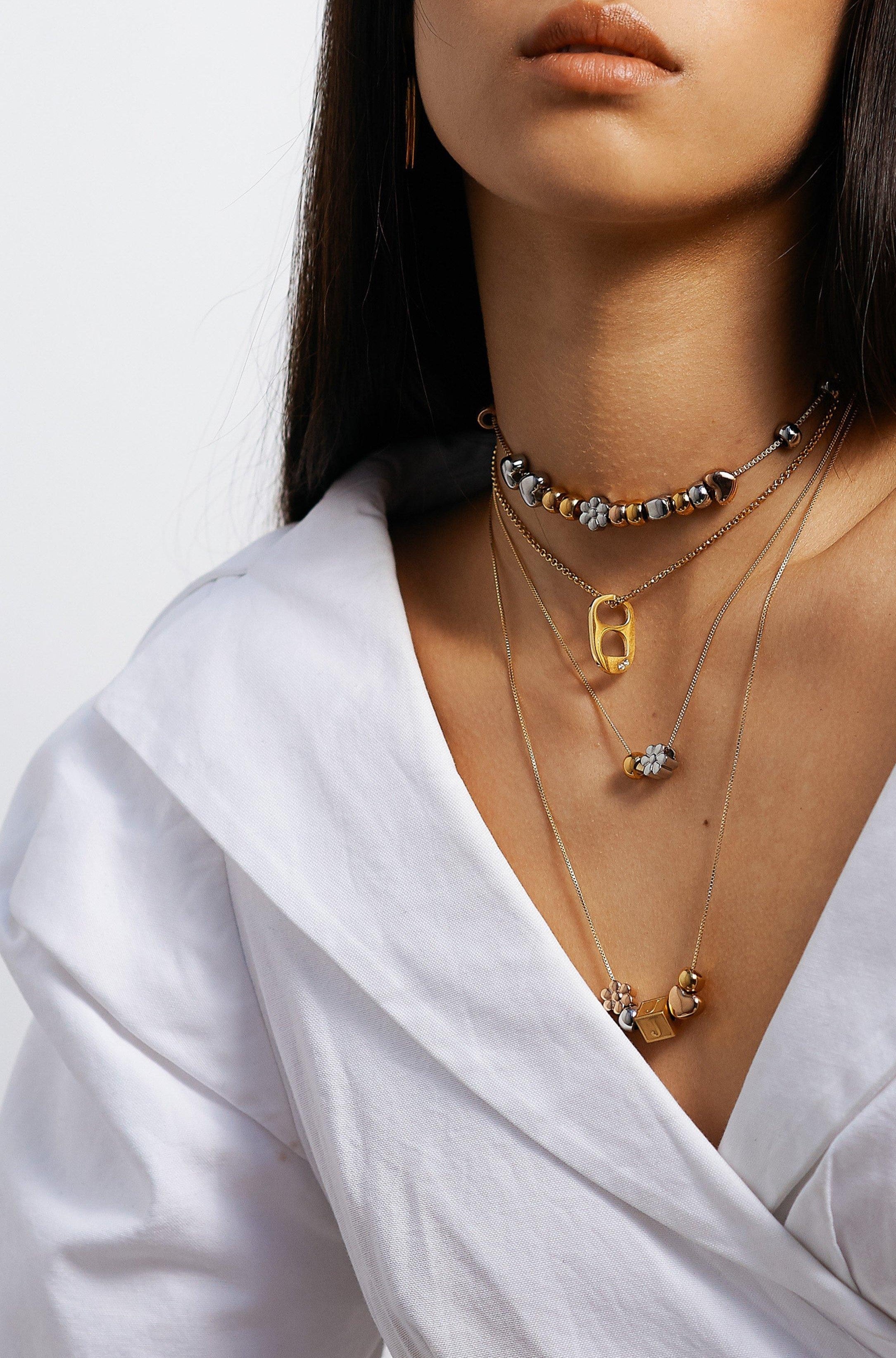 Model wearing 4 necklaces layered with Letter Block letters Bagatiba