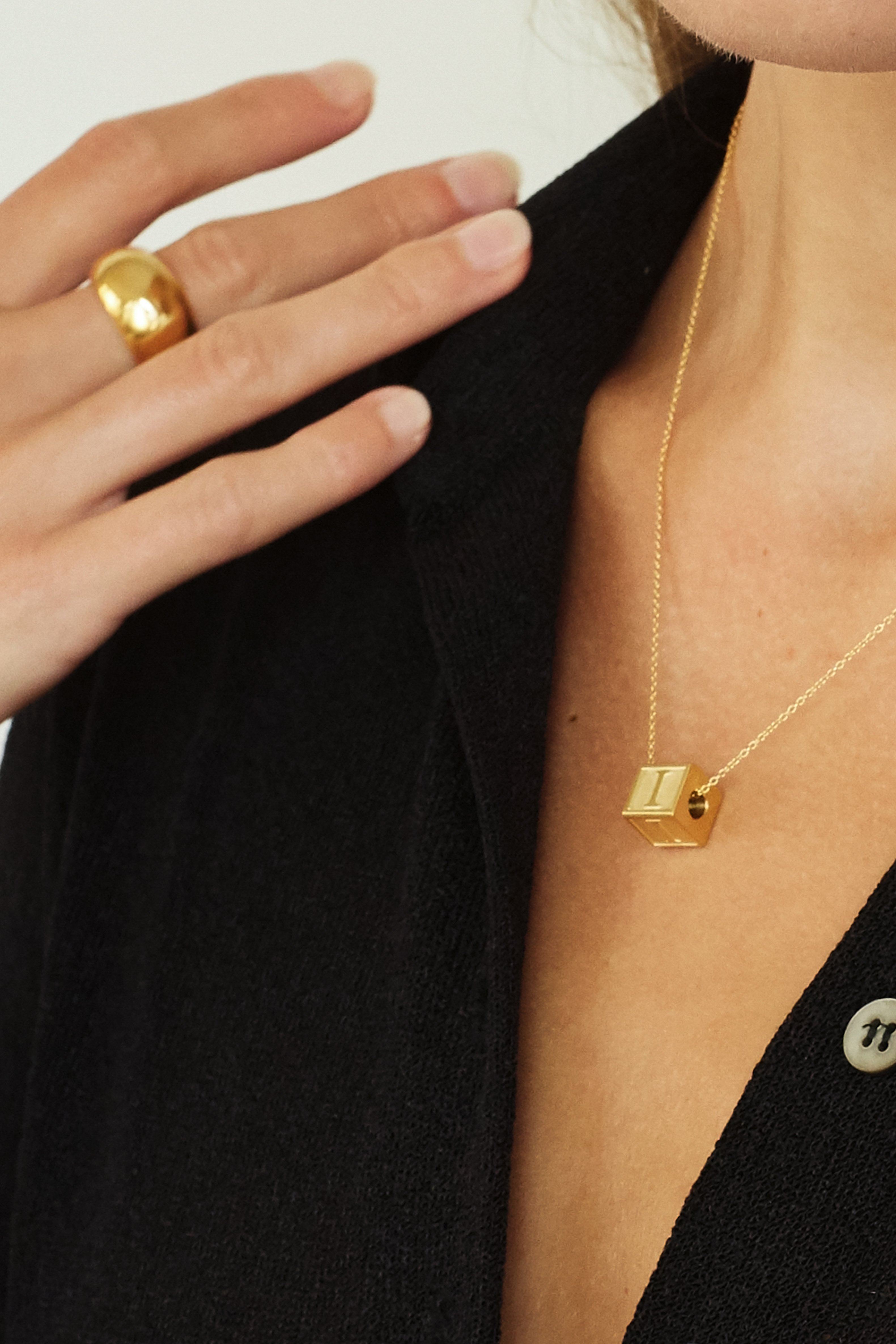 Close up on model of "I" Letter Block letter and small gold orb ring  Bagatiba 