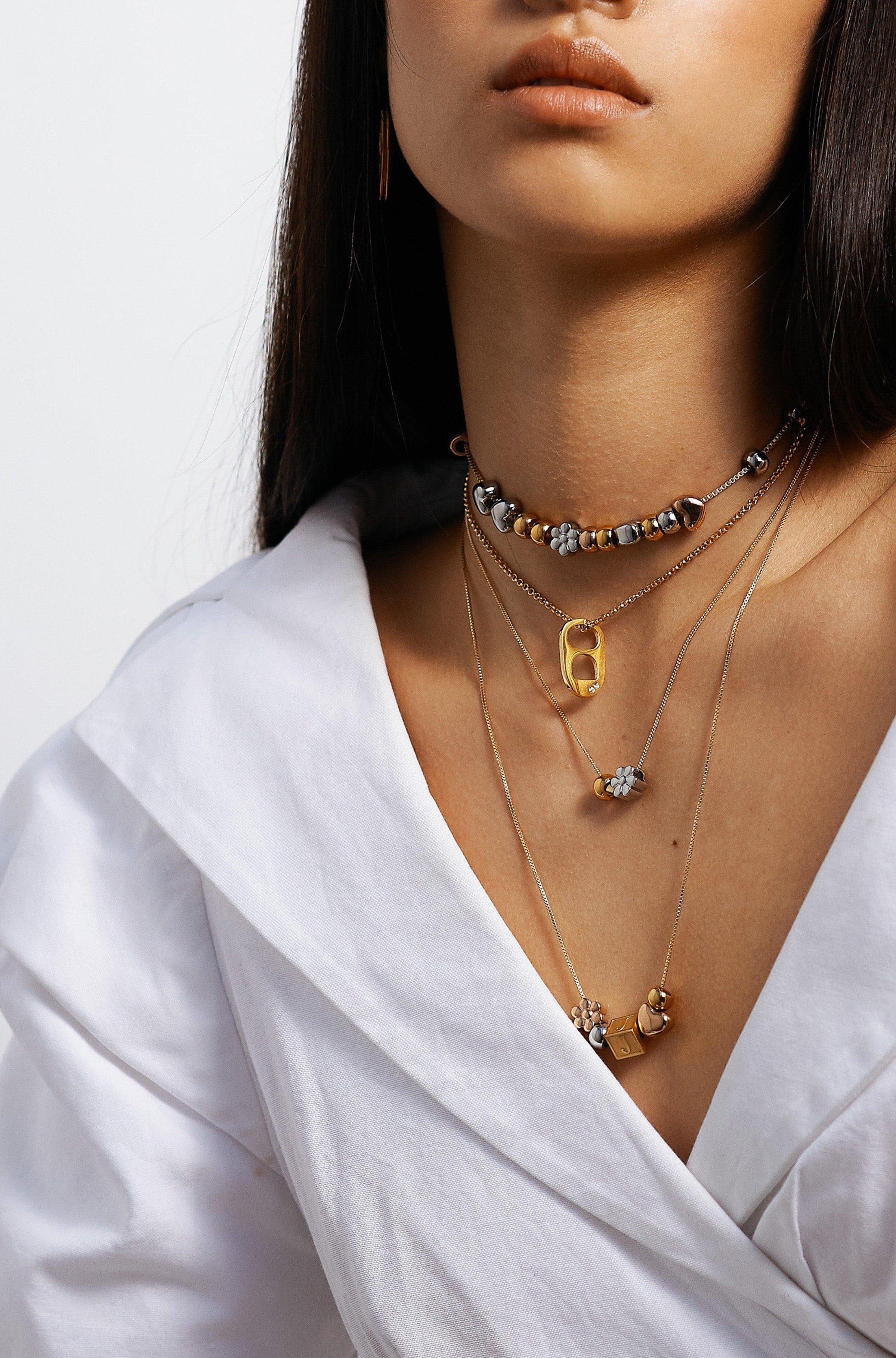Model wearing 4 necklaces layered with Letter Block letters Bagatiba