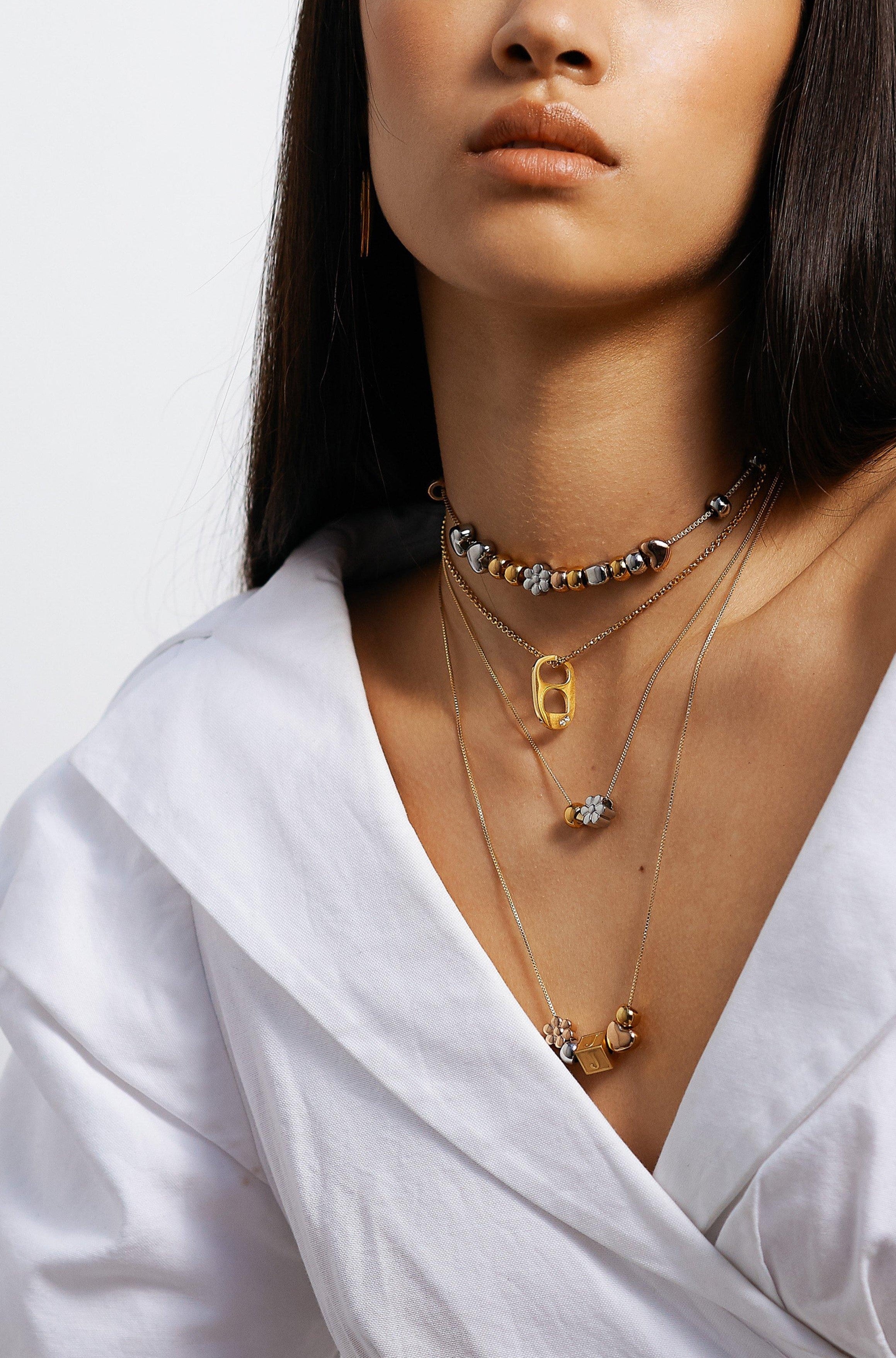 full view of model wearing 4 necklaces layered with "G" Letter Block letter on chain Bagatiba