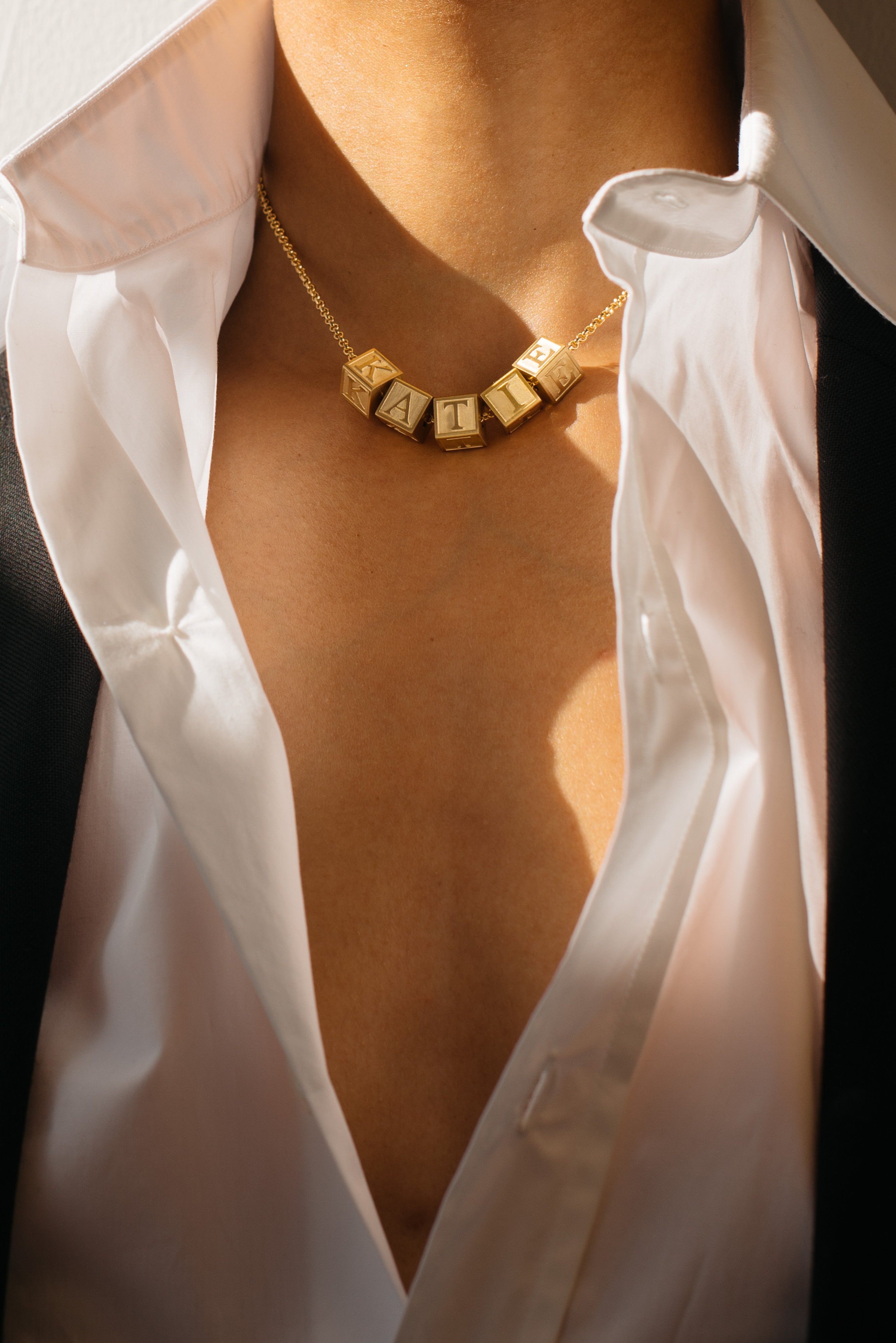 Close up view of Model wearing 5 Letter Block letters on chain Bagatiba