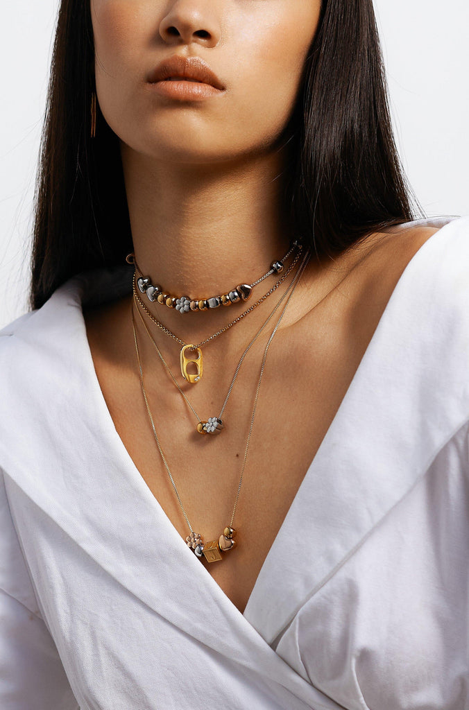 Model wearing 4 necklaces layered with  Letter Block letters Bagatiba 