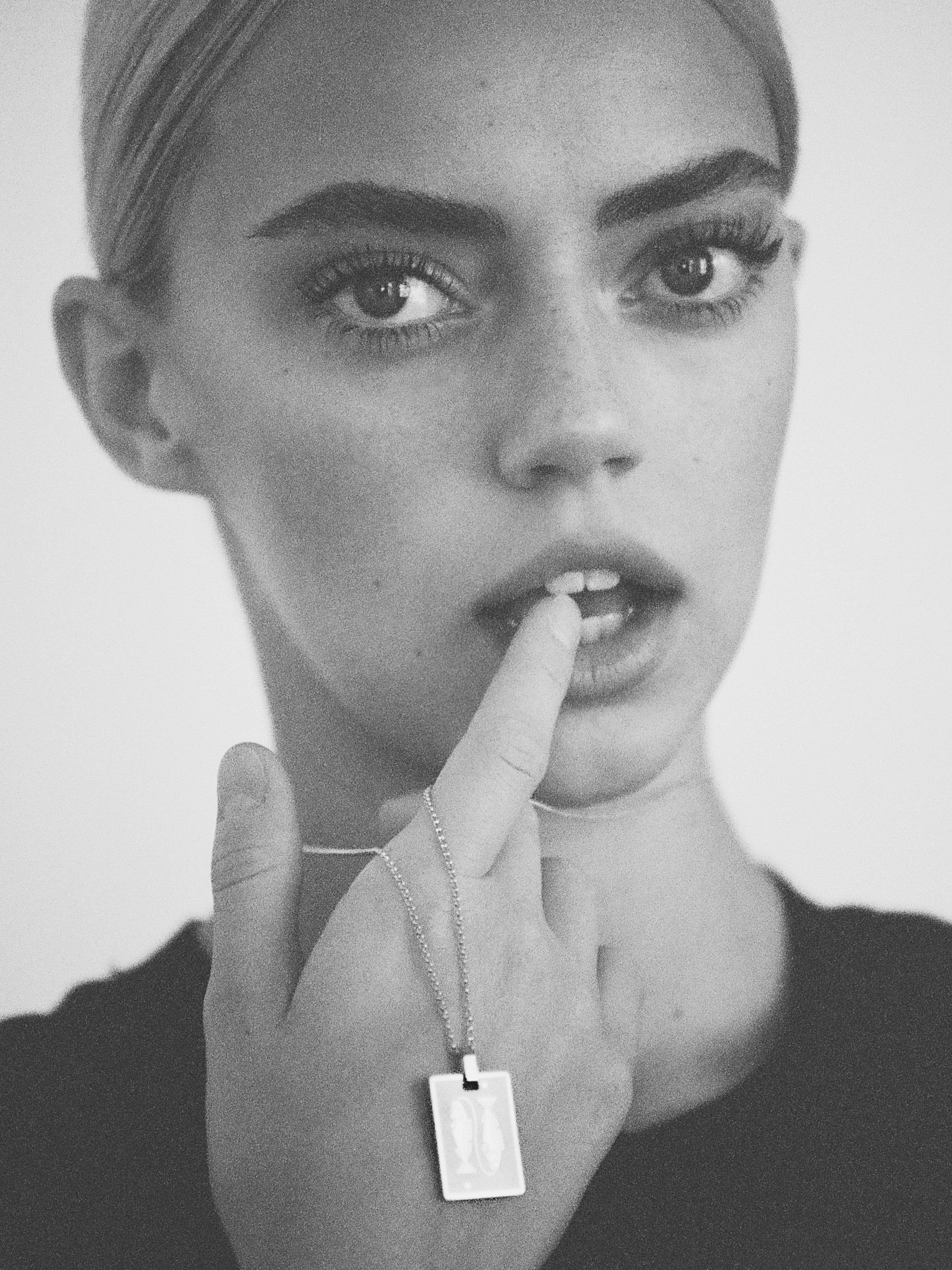 Black and White image of a woman wearing the Pisces Charm charm by Bagatiba
