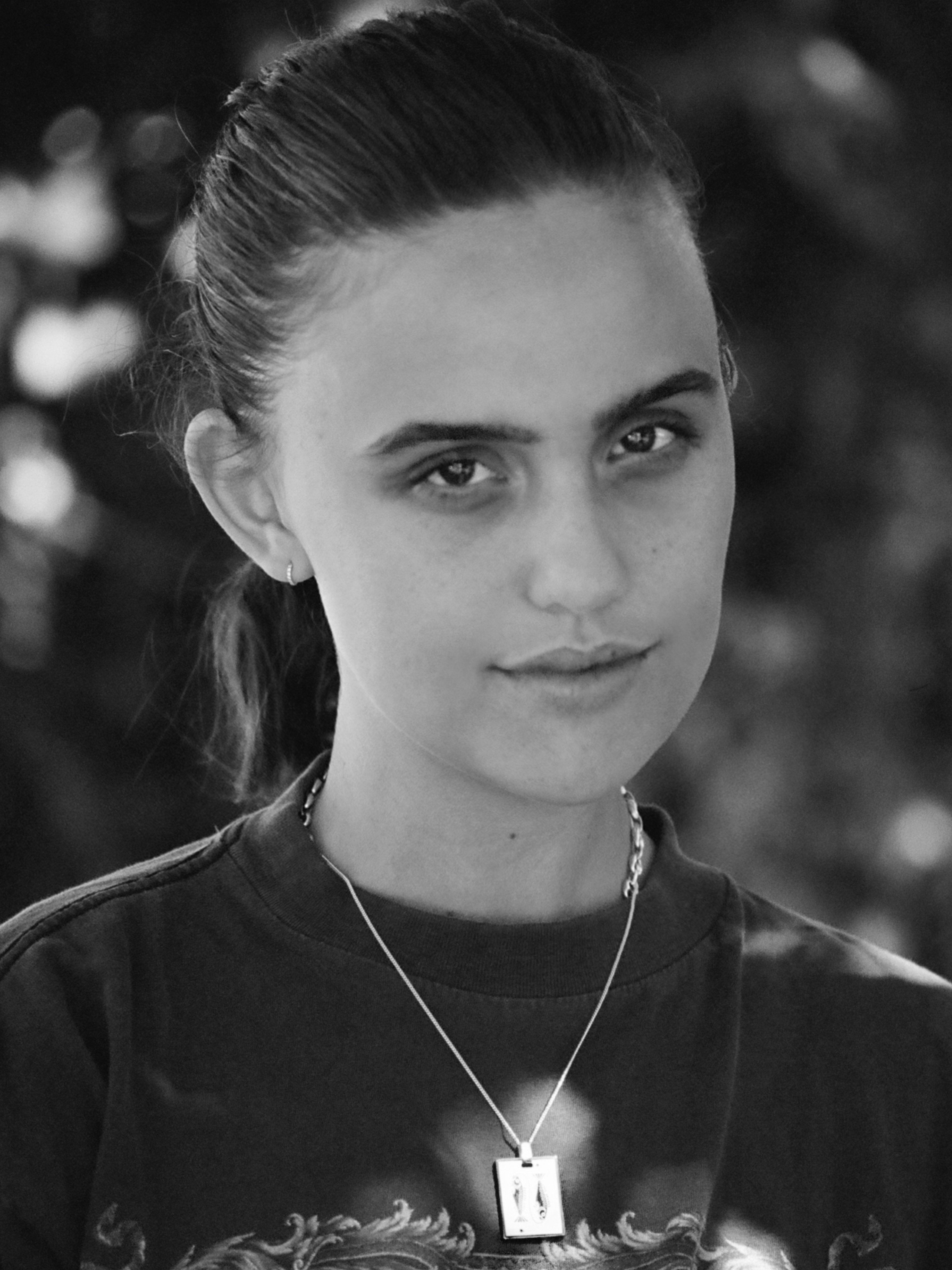 Black and White image of a woman wearing the Pisces Charm charm by Bagatiba