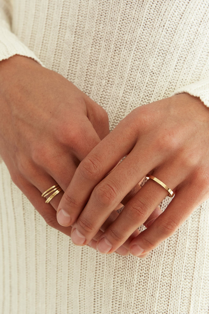 Model's hands wearing 4 Polished Gold Rings stacked on one finger  Bagatiba 
