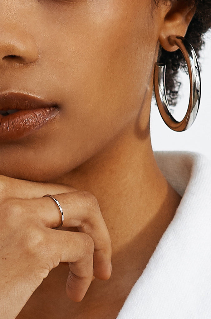 Profile photo of the Polished Silver Ring styled with silver hollow hoops by Bagatiba 