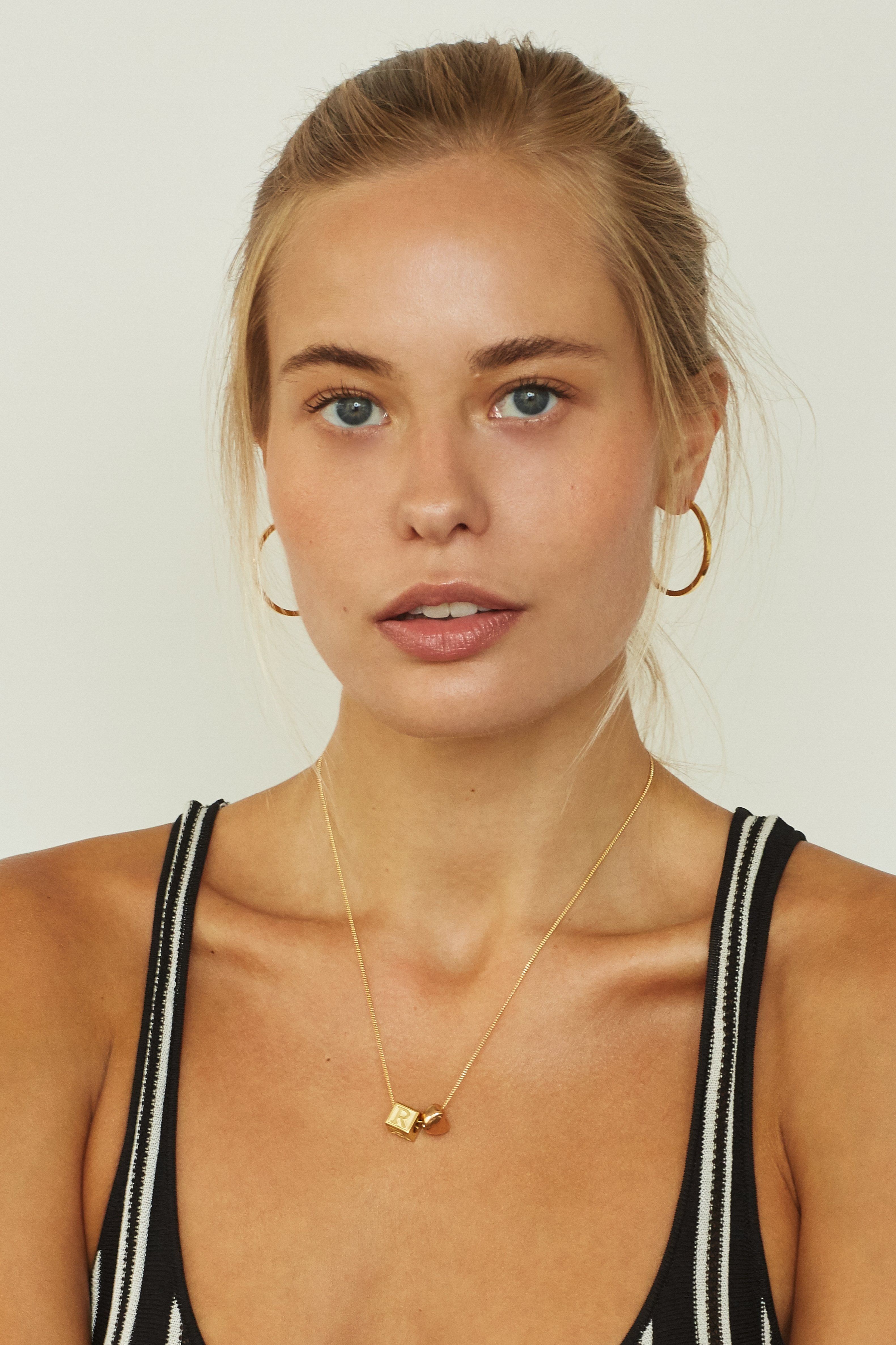 Model wearing "R" Letter Block letters paired with simple gold hoops Bagatiba 