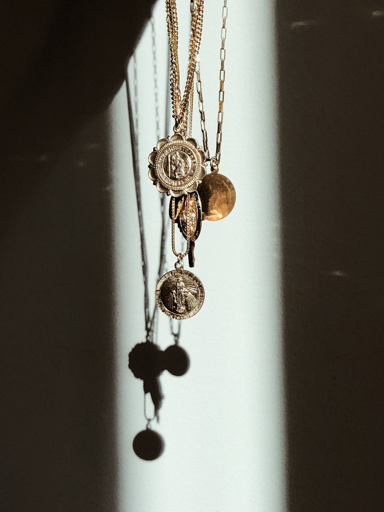 Saint Christopher Crest Necklace among others in natural sunlight  Bagatiba 