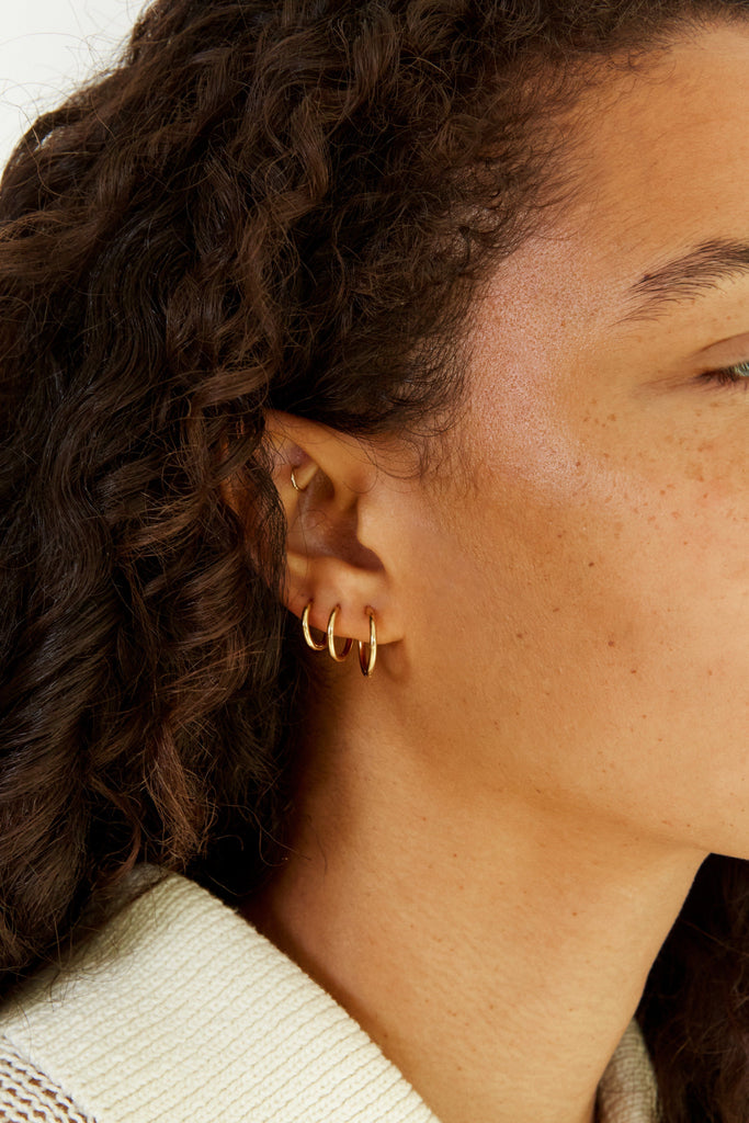 Set of Gold Eco Huggies Earrings shown on model's ear  Bagatiba 