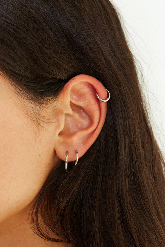 Detail view on model's ear of Set of Silver Eco Huggie Hoops Earrings Bagatiba 