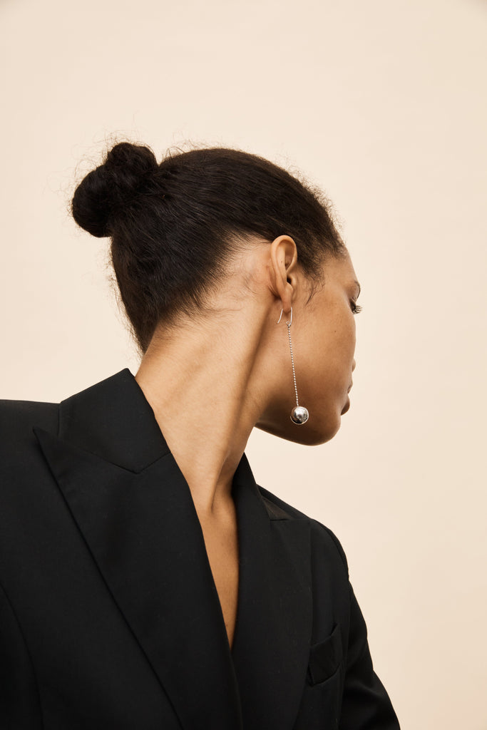 Model wearing the Silver Drop Sphere Earrings by bagatiba styled with hair pulled back