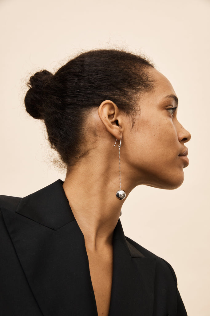 Model wearing the Silver Drop Sphere Earrings by bagatiba styled with hair pulled back