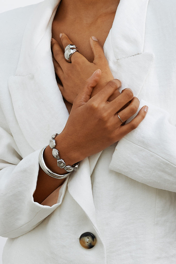 Cropped detail view of model's torso wearing Silver Orb Cuff Bracelet paired with other Silver items by bagatiba