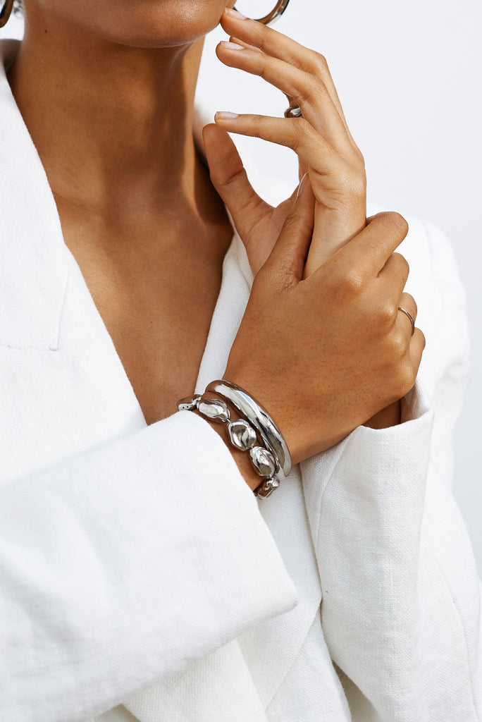 Detailed view of model's wrist wearing Silver Orb Cuff and Silver Pearl Bracelet bagatiba 