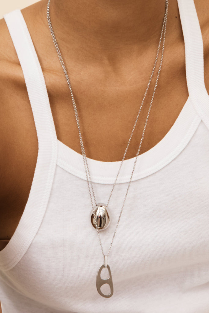 Detailed view on model of Silver Orb Necklace and Silver Tab Adjustable  Necklace bagatiba 