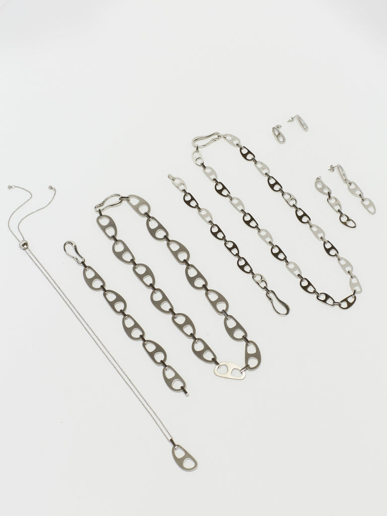 Detailed flat lay of Silver Tab Drop Earrings with the full Silver Tab Collection by  bagatiba 