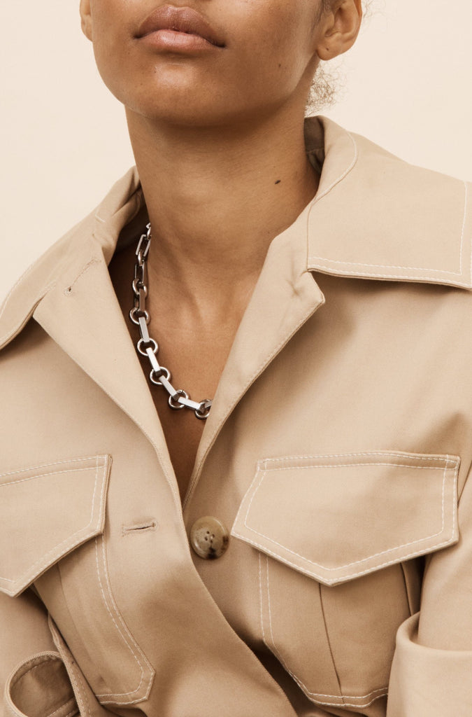 Full view of model in the Silver Tilda Necklace by bagatiba styled with a trench coat