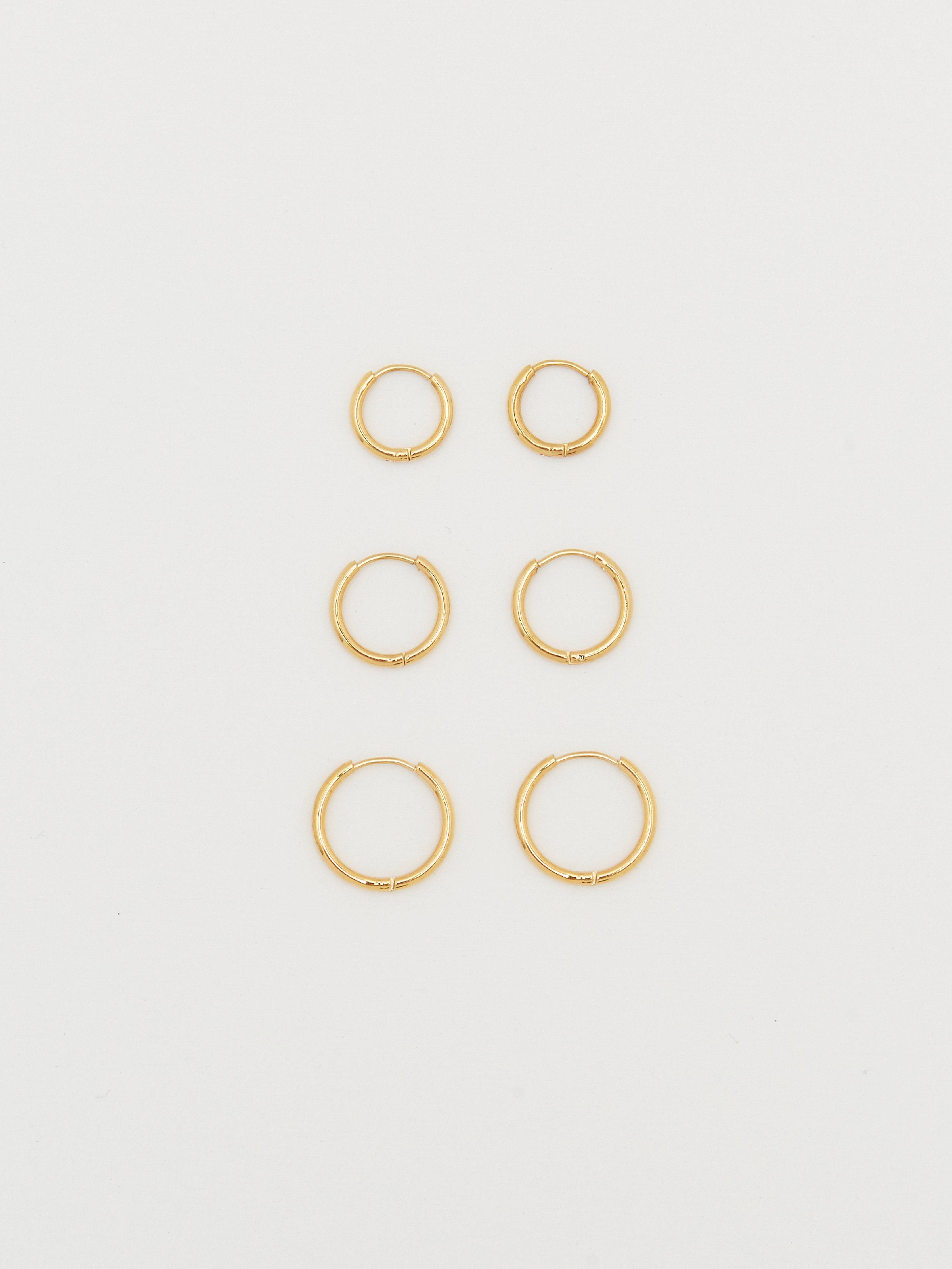 Full view flat lay of the Small, Medium & Large  Gold Eco Huggies Earrings Bagatiba 