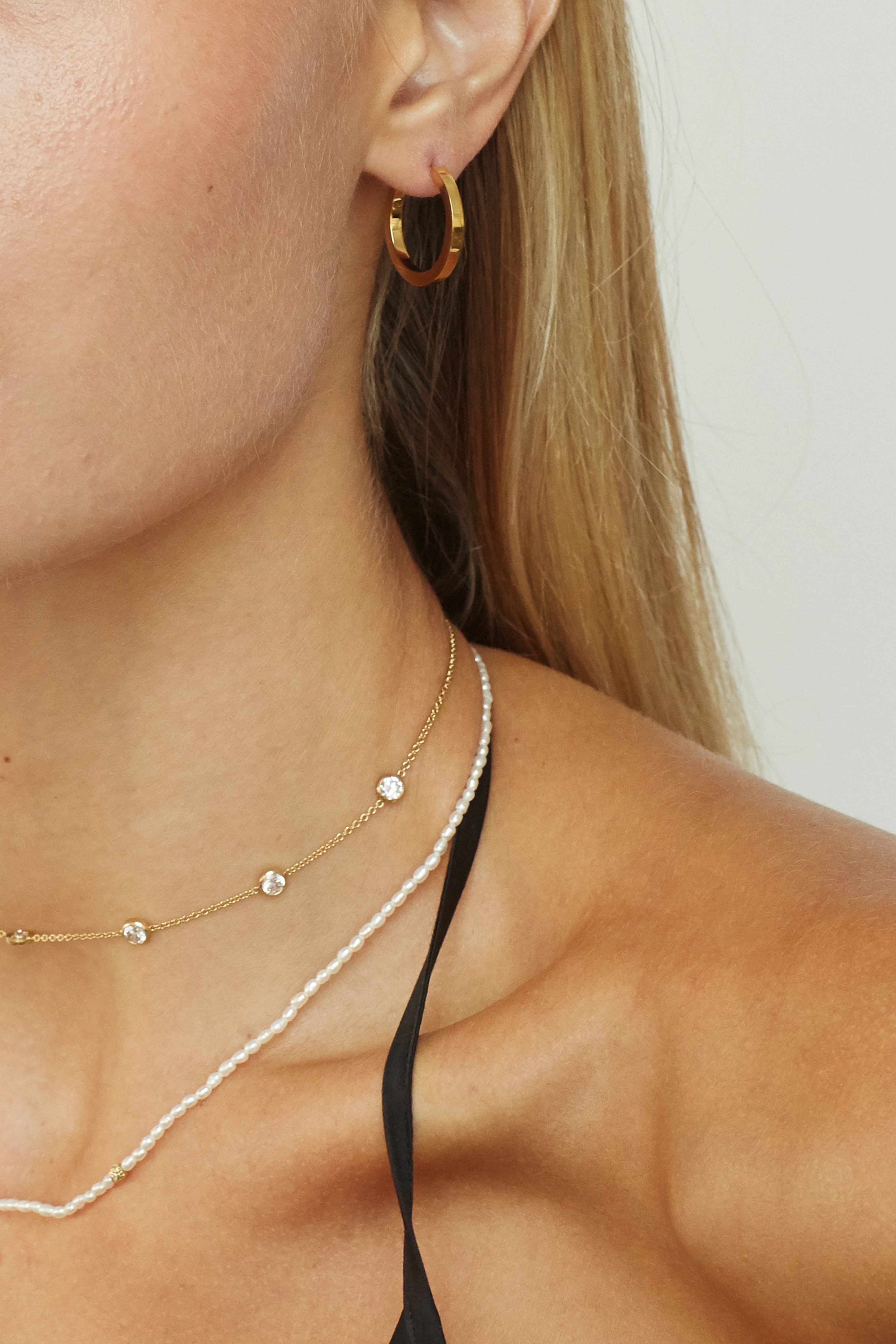 Detail view on ear of Small Simple Gold Hoops Earrings Bagatiba 