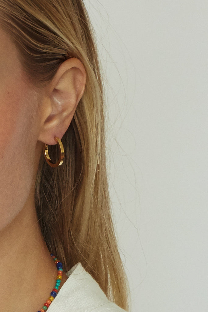 Cropped view on ear of Small Simple Gold Hoops Earrings Bagatiba 