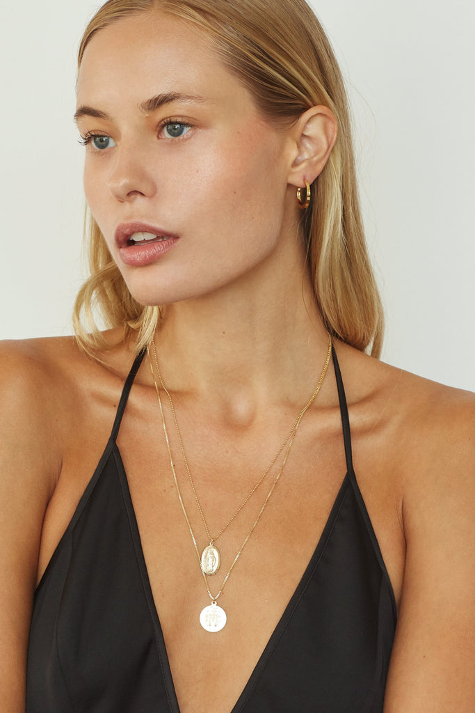 Profile view of model in the Small Simple Gold Hoops Earrings Bagatiba 