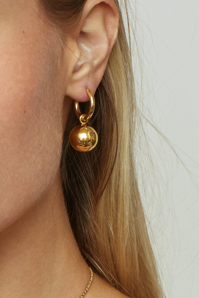 Cropped view on Model's ear of Sphere Hoops Earrings bagatiba 