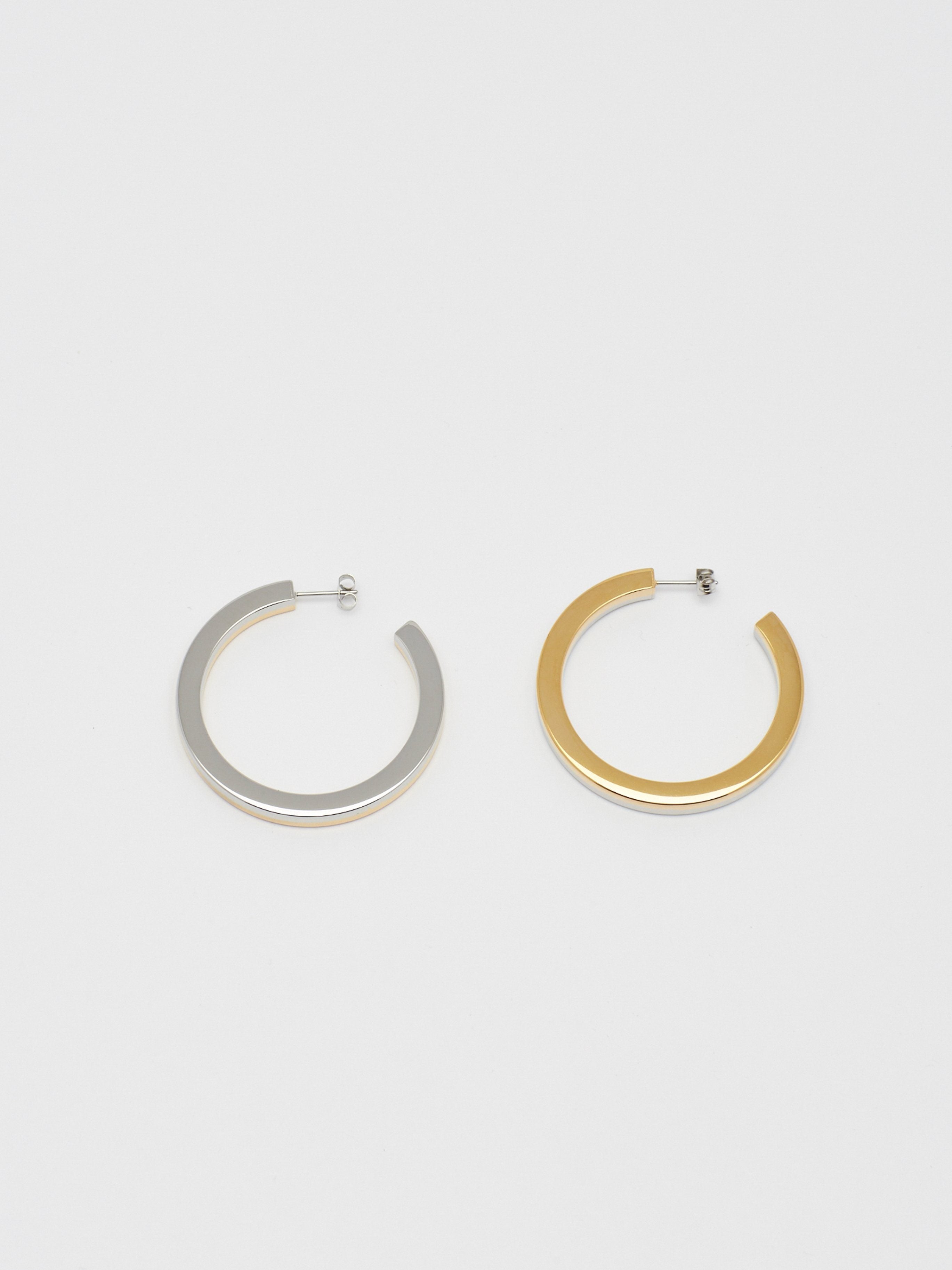 Flat lay of the Two Tone Flat Hollow Hoops Earrings Bagatiba 