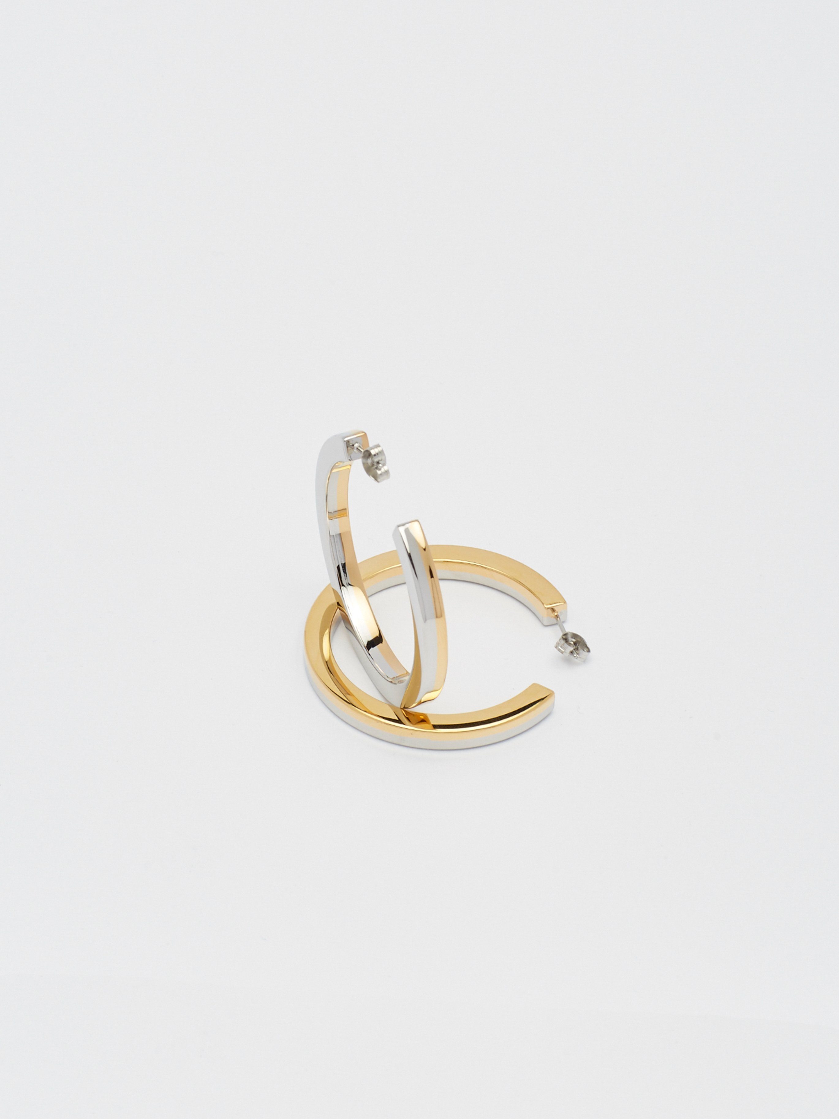 Detail flat lay view of the Two Tone Flat Hollow Hoops Earrings Bagatiba 