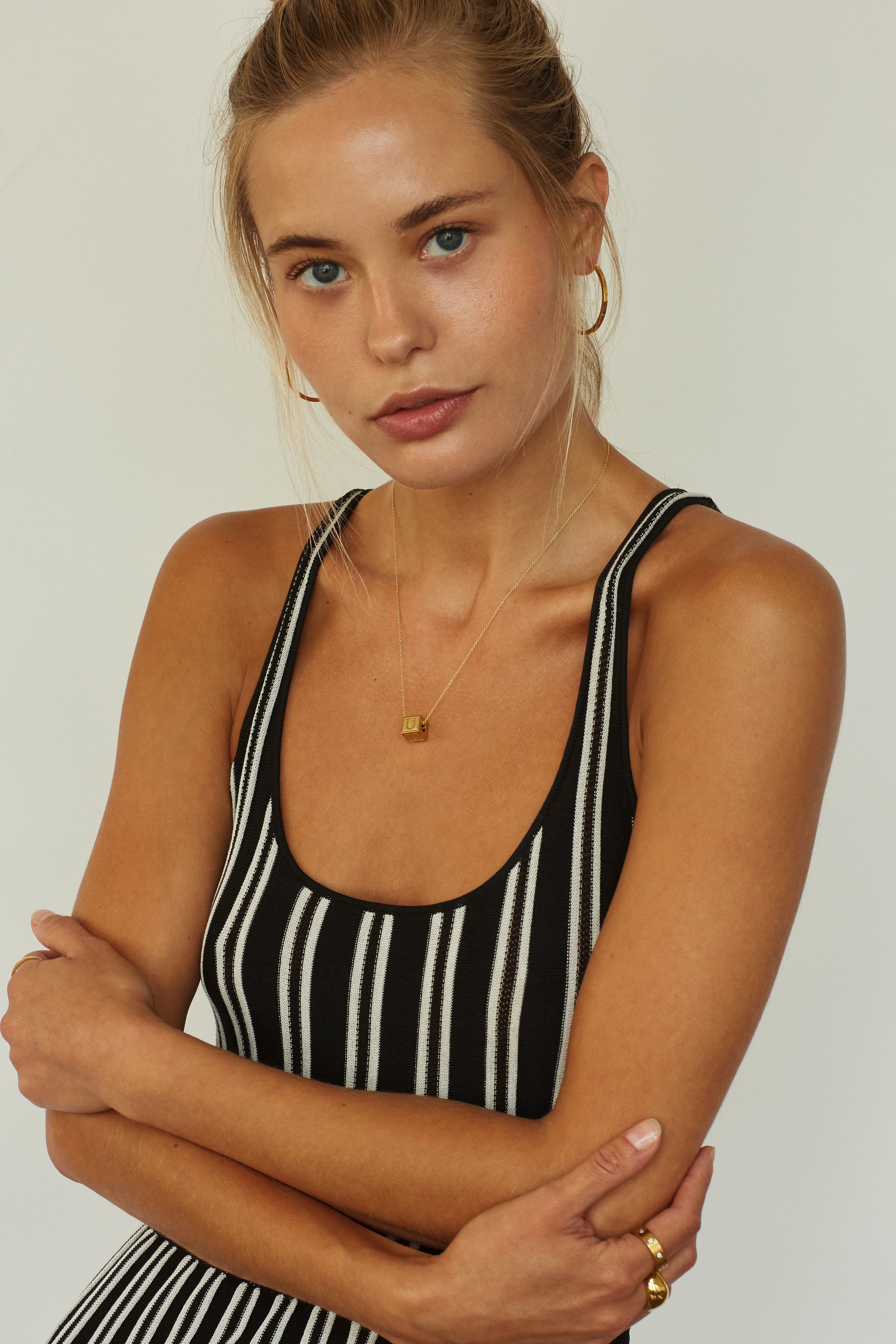 Full view of model wearing "U" Letter Block letters paired with simple gold hoops and orb rings  Bagatiba 