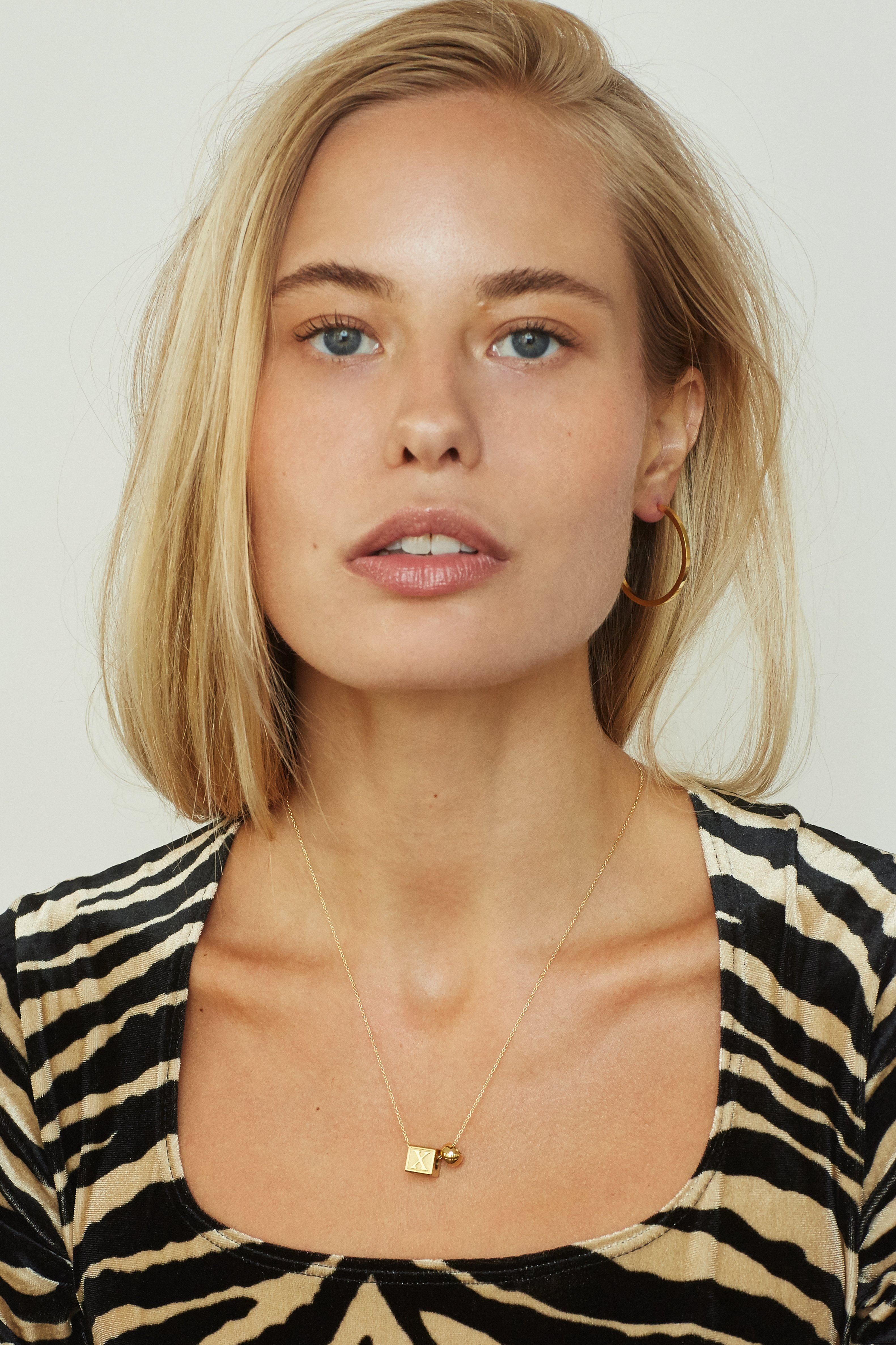 Model wearing "X" Letter Block letters paired with simple gold hoops  Bagatiba 